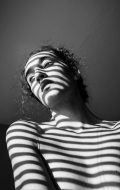 Vendula Spáčilová, „Ve stínu pruhů“  Střední škola uměleckomanažerská, s.r.o., Brno  1.	místo v kategorii SŠ 2018 – I. Portrét  Fotografie vznikla náhodou, když vylezly příjemné paprsky poledního slunce. Snímek pořízen na Sony NEX-5